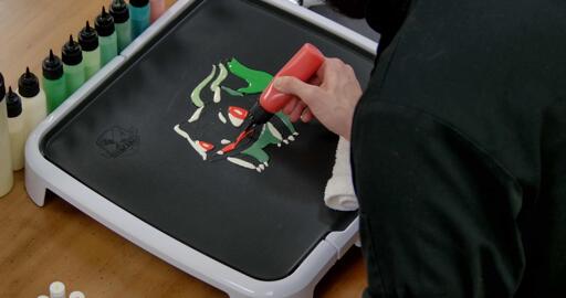 Bulbasaur pancake art step 5.1: Draw a red curved line for bulbasaur's tongue, and color in the mouth above with red batter.