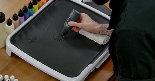 Charmander Pancake Art step 1.1: Begin the process by using your black batter to outline Charmander's facial features. Try to keep them small.