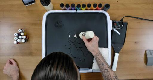 Charmander Pancake Art step 2.1: Grab your white batter and color in ovals at the center of Charmander's eyes. One of the eyes has a little white at the edge, too.