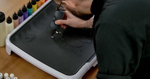 Charmander Pancake Art step 2.2: Grab your black batter again and color in a rounded shape in each eye - these are charmander's pupils.