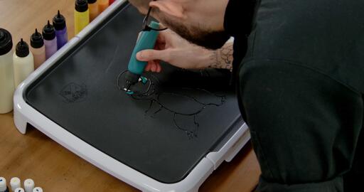 Charmander Pancake Art step 2.3: For the rest of Charmander's irises, use your blue-green and fill that area.