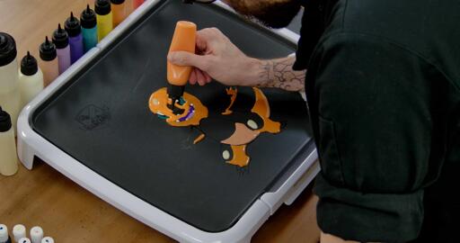Charmander Pancake Art step 6.1: With your bold orange batter, begin filling in the rest of Charmander's face, arms, legs, and the top of Charmander's tail.