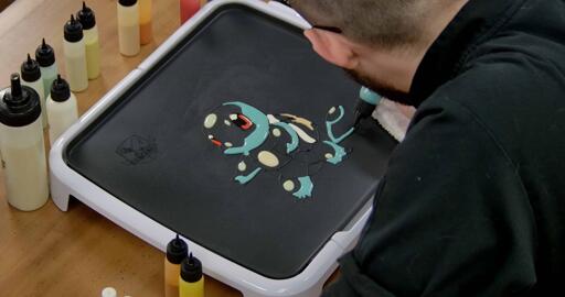 Squirtle Pancake Art step 4.1: Using your darkest blue batter, begin to fill in shading zones on Squirtles head, arms, legs and tail, like so.