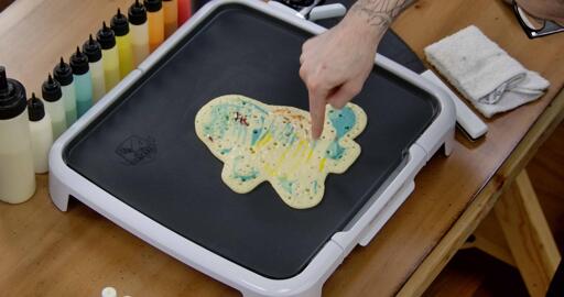 Squirtle Pancake Art step 7.2: As the pancake cooks you'll see bubbles appear on the back, like so. You want bubbles to appear across the whole back and for the batter to stop looking shiny as the pancake cooks through.