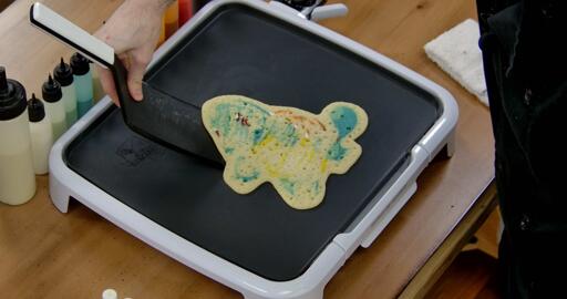 Squirtle Pancake Art step 7.3: When the pancake is cooked all the way through, you can start 'carving' it from the griddle. Use the flat edge of your spatula to gently ease the pancake off the griddle. When the whole pancake gently releases, you can get it to slide across the griddle, and that's how you know it's time to flip!
