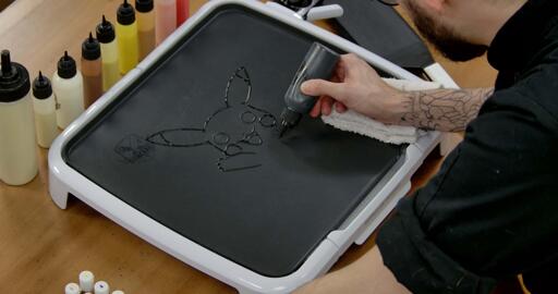 Pikachu Pancake Art step 1.2: Continue to outline Pikachu - two round circles for the cheeks, cute little arms, the outline of the head and the ears (with a line drawn for the black tips at the ends of the ears).