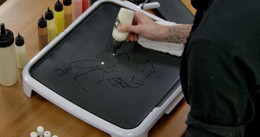 Pikachu Pancake Art step 2.1: Time to color in the eyes! Grab your white batter and add little dots to the interior of Pikachu's eyes. These 'glints of light' will add a ton of personality to the final product.