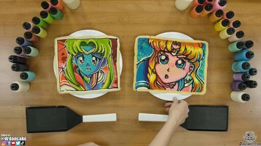 Dan and Dana's attempts at the Sailor Moon redraw challenge! Dan's pancake illustration is mostly on-model with Sailor Moon, but he used a blue, green and red color scheme that makes the character seem alien and exotic. Dana's pancake art of sailor moon uses a looser, charming style with bright, popping colors and bold lines and curves.