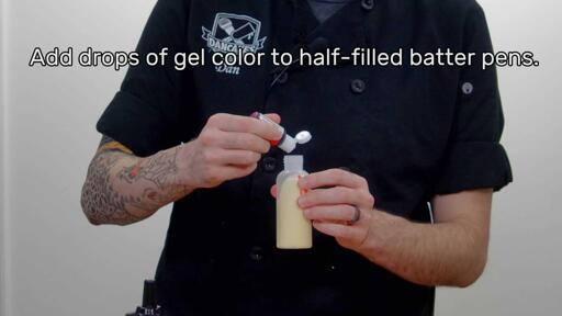 An image of a red coloring gel being added drop by drop into an open, half-filled batter pen. The image reads