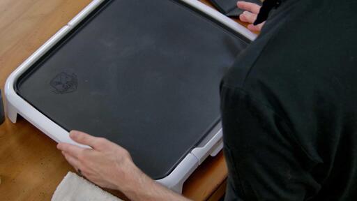 An image of the dancakes griddle over the artists left shoulder. The surface is clean and has no non-stick sprays or coatings applied to it.