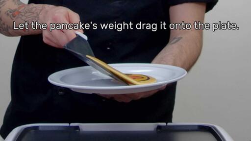 An image of the heart eyes emoji pancake design being plated, with the text