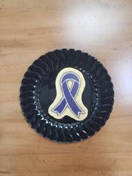 Pancake art of a simple purple awareness ribbon, representing epilepsy awareness. The outlines are done in white, adding a sense of shininess to the ribbon.