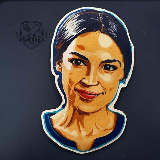 A photograph of a pancake art portrait of representative Alexandria Ocasio-Cortez, a united states politician and public figure. She is smiling, lips closed.